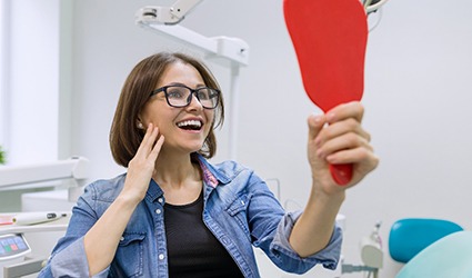 young woman admiring her new dental implants in Park City