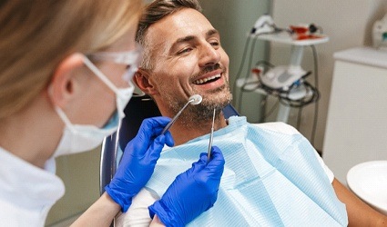 person smiling and sitting in dentist’s chair